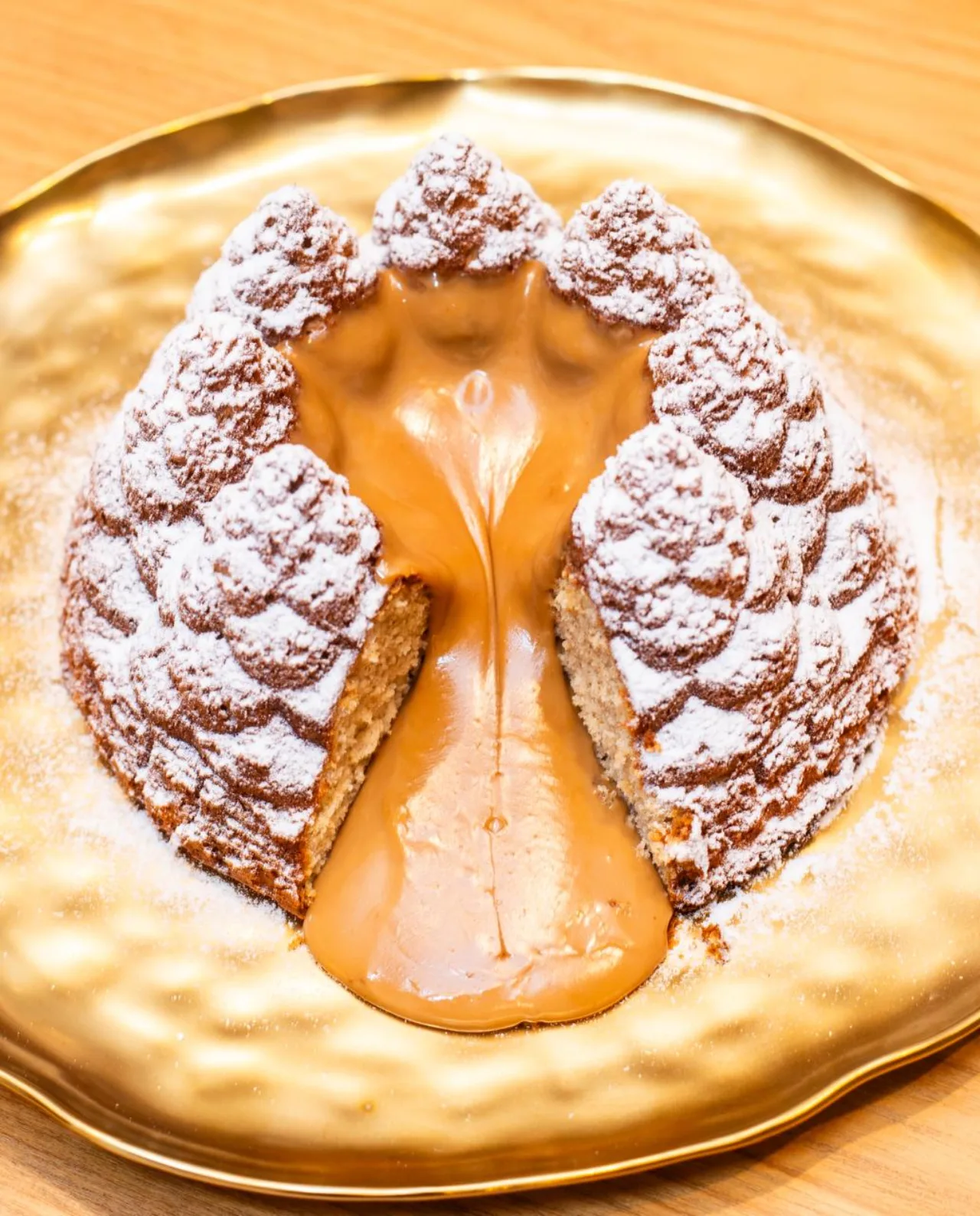 Bolo em formato de pinha com doce de leite sobre prato dourado — Natal